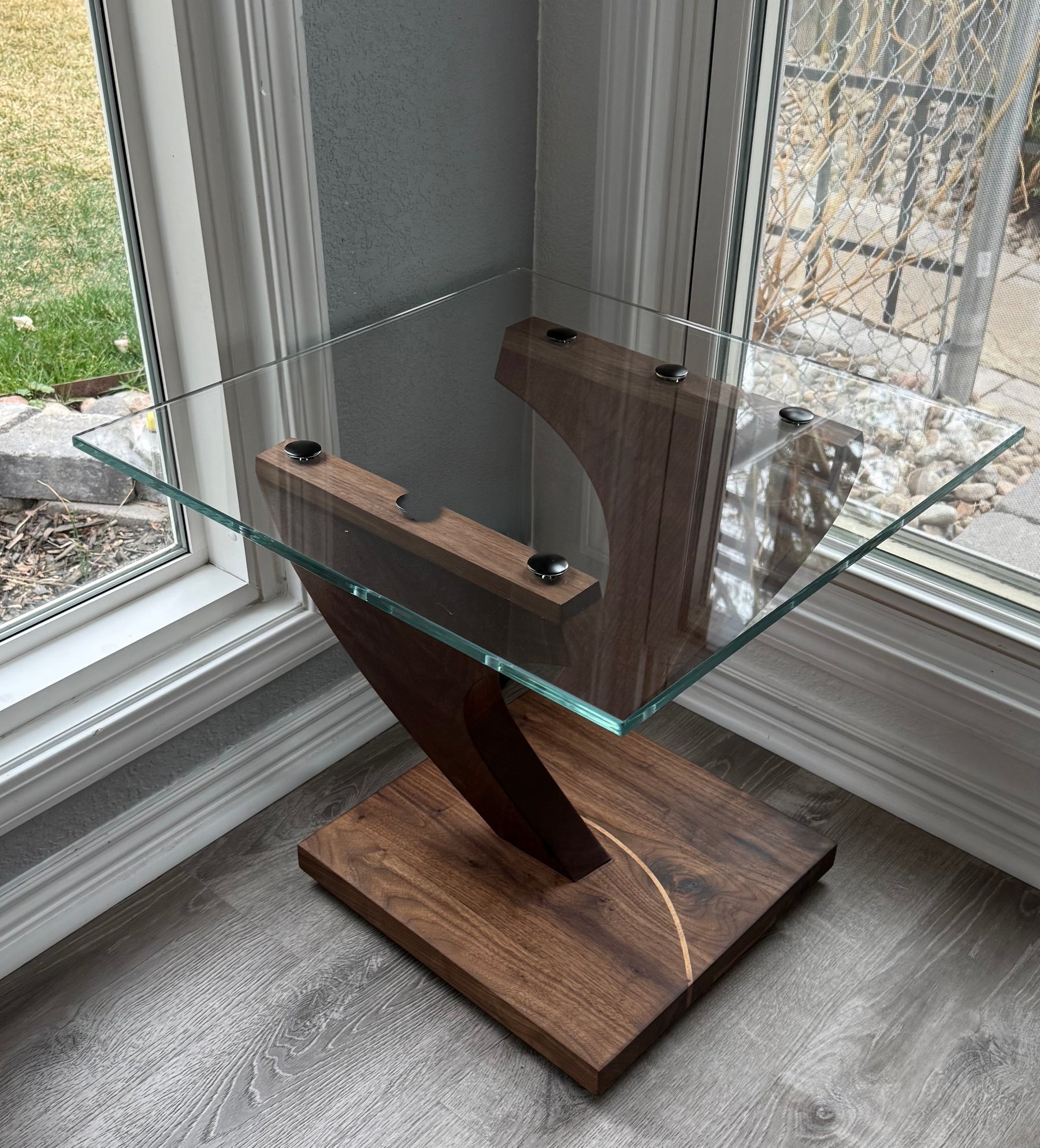 Suspended glass end table with angled black walnut supports