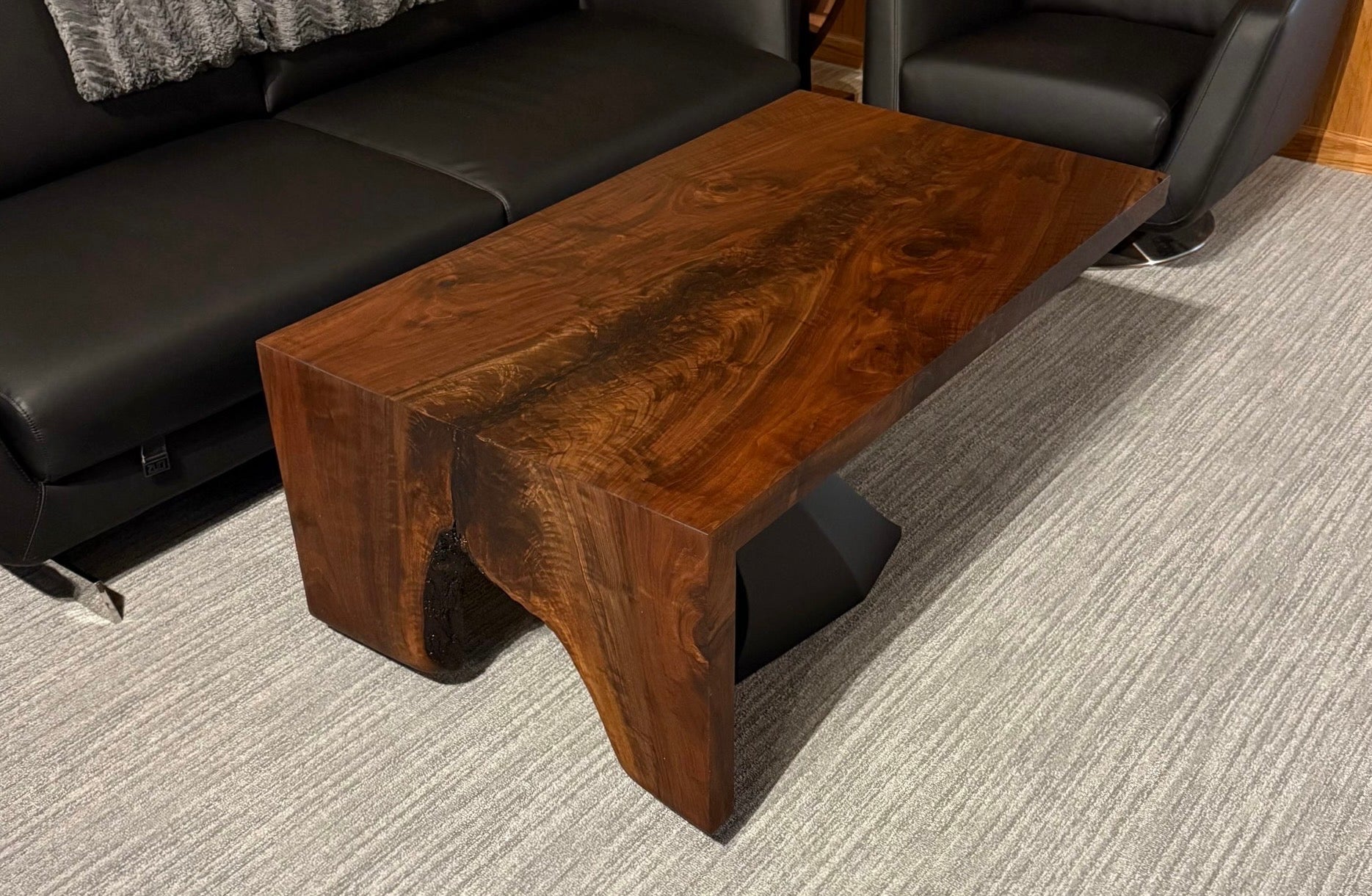 Black walnut waterfall coffee table in a bright living room